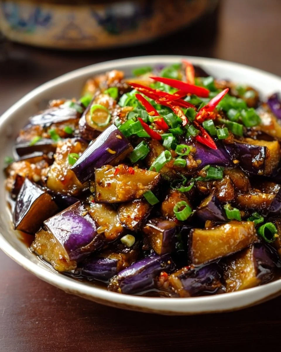 Serving of Chinese eggplant in garlic sauce garnished with herbs and spices