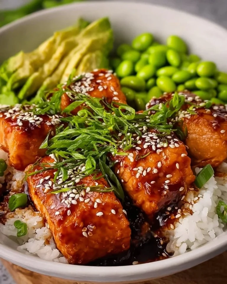 Flaky teriyaki salmon bowls topped with fresh vegetables and served in a vibrant dish.