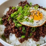 Korean beef bowl featuring tender beef, rice, and colorful vegetables.