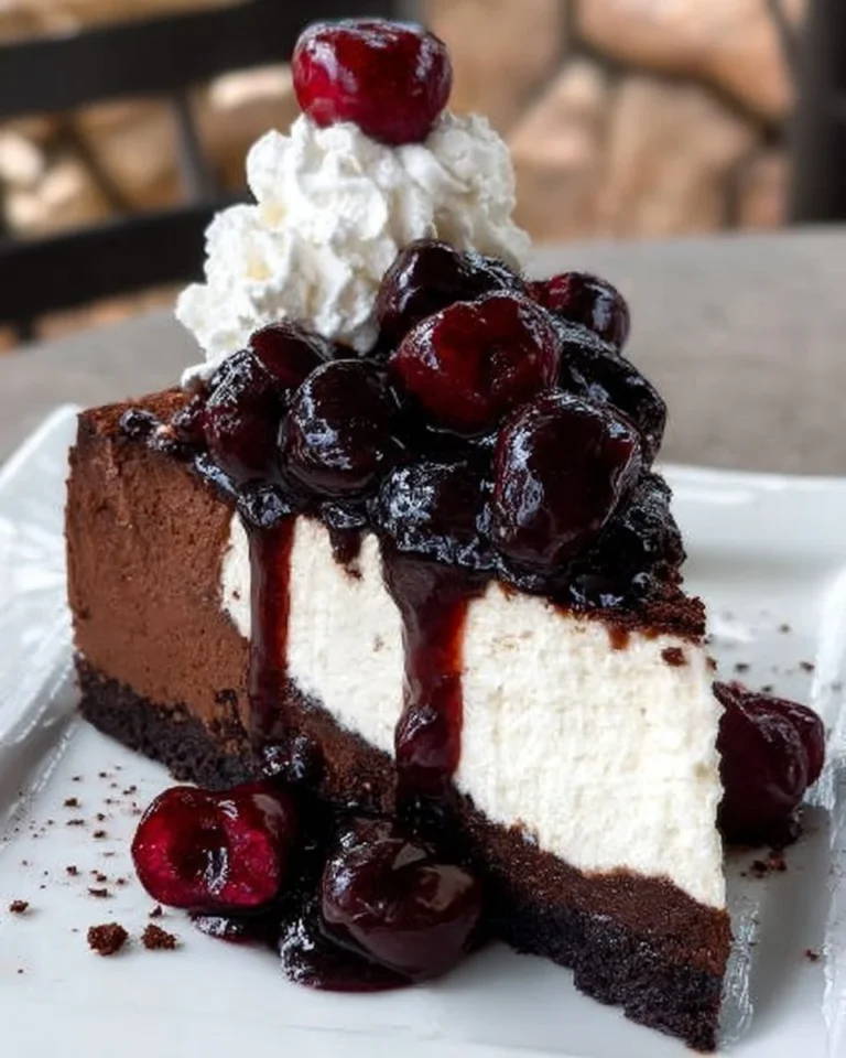 A decadent Black Forest Cheesecake Cake topped with cherries and chocolate shavings.