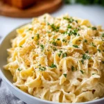 Bowl of creamy cafeteria noodles topped with herbs and spices
