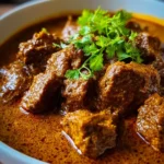 Delicious homemade lamb curry served with rice and garnished with cilantro.