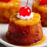 Mini pineapple upside down cakes displayed on a dessert platter