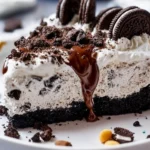No Bake Oreo Dirt Pie topped with crushed Oreos and chocolate in a glass dish