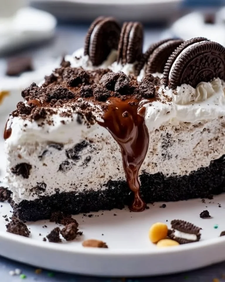 No Bake Oreo Dirt Pie topped with crushed Oreos and chocolate in a glass dish