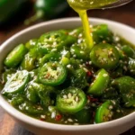Homemade jalapeño lime hot sauce in a glass bottle with fresh ingredients