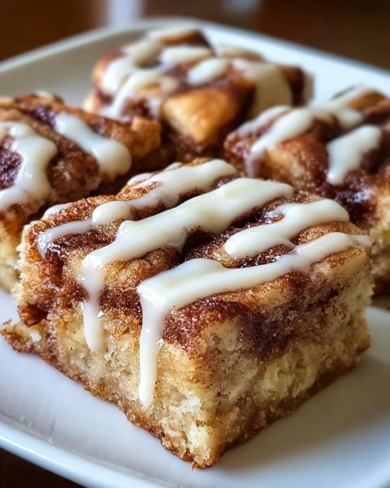 Delicious cinnamon roll bliss bars topped with creamy frosting and cinnamon.