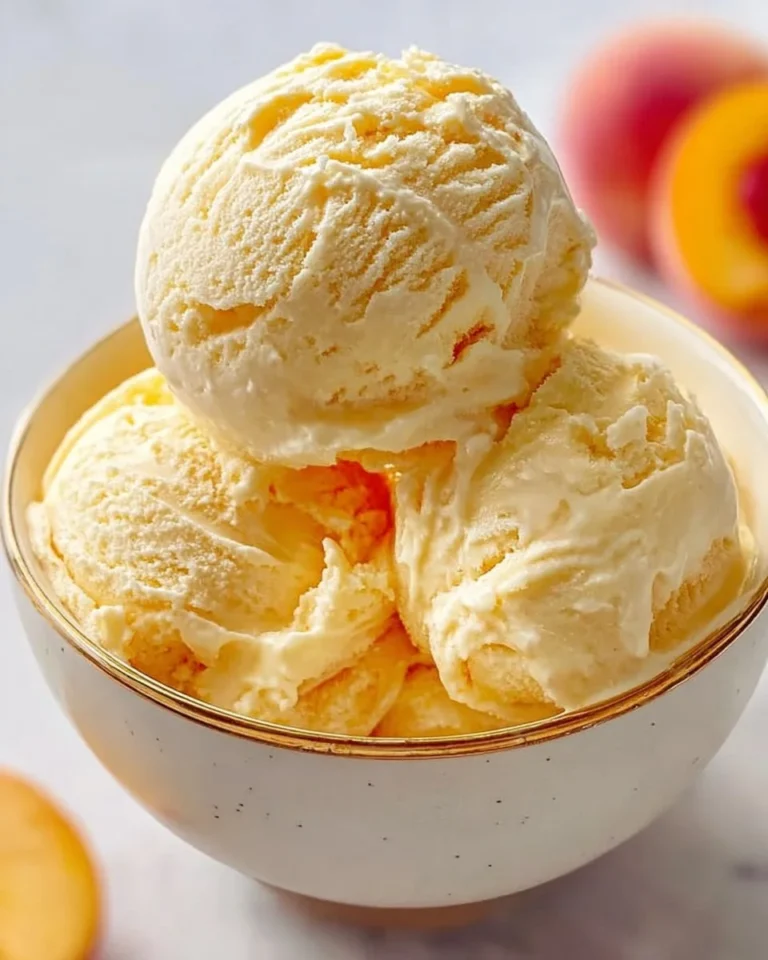 Bowl of classic peach custard ice cream topped with fresh peaches.