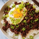 Delicious Korean ground beef bowl topped with fresh vegetables and spices.