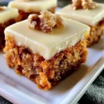 Delicious carrot cake bars topped with creamy frosting on a plate